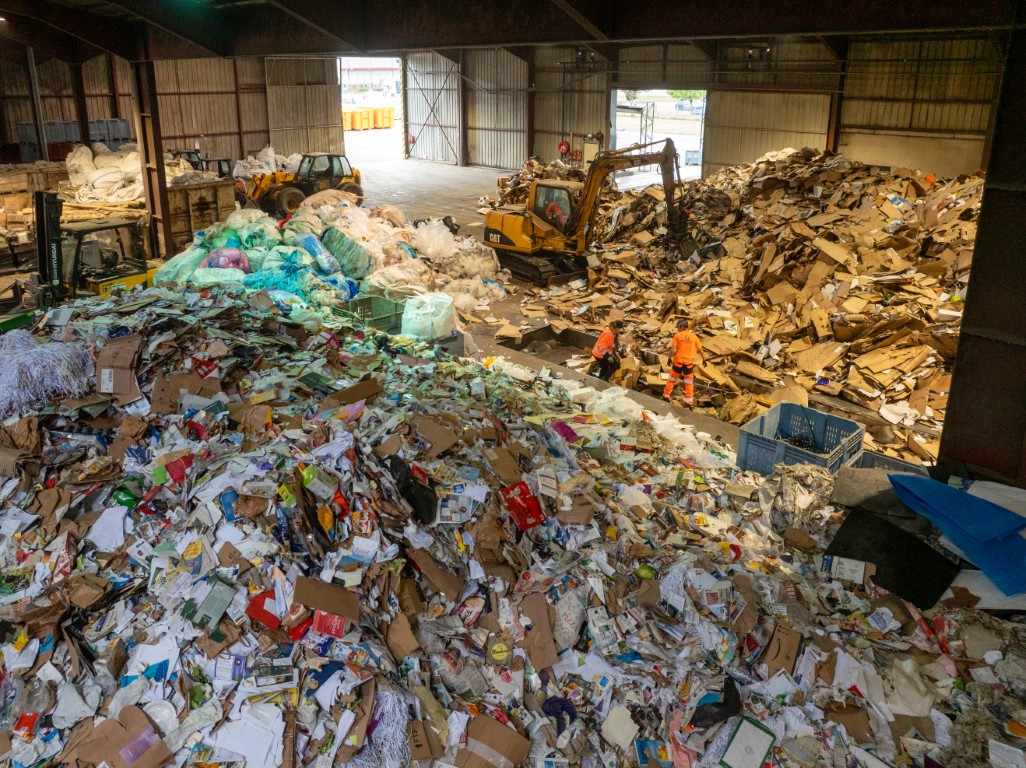 Centre de tri DIB : pelle mécanique et agents triant cartons, plastiques et papiers